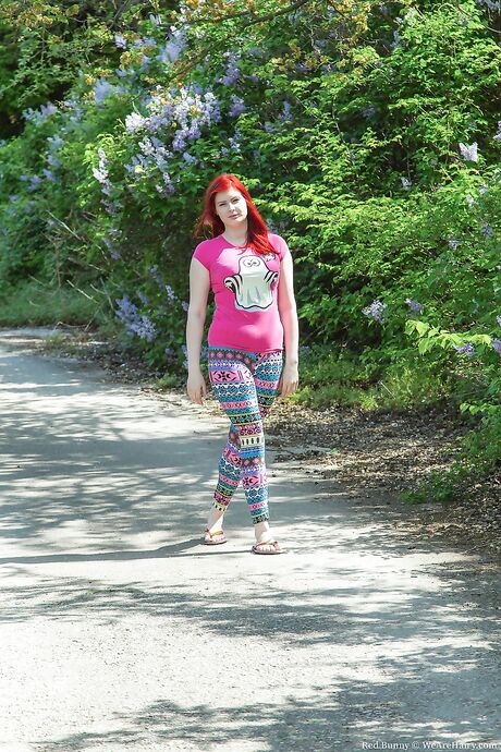 Cute redhead with big chest Red Bunny shows her hairy twat outdoors